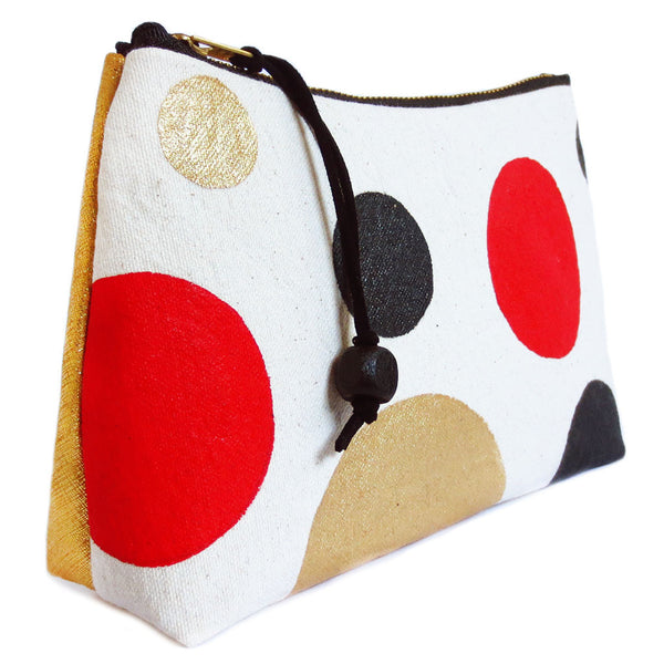 side view of gold leather and painted polka dot canvas zip pouch