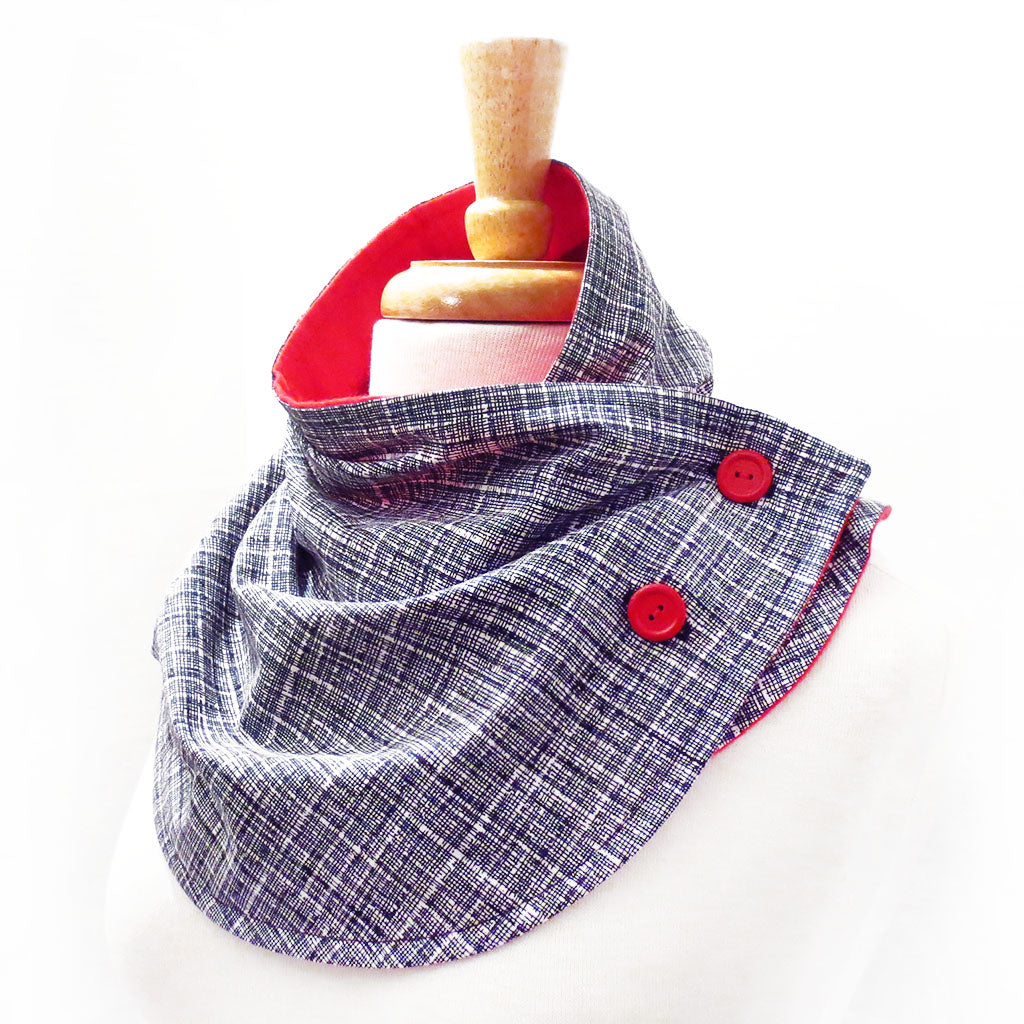 button scarf in black and white crosshatch print, lined in bright red flannel with two red buttons