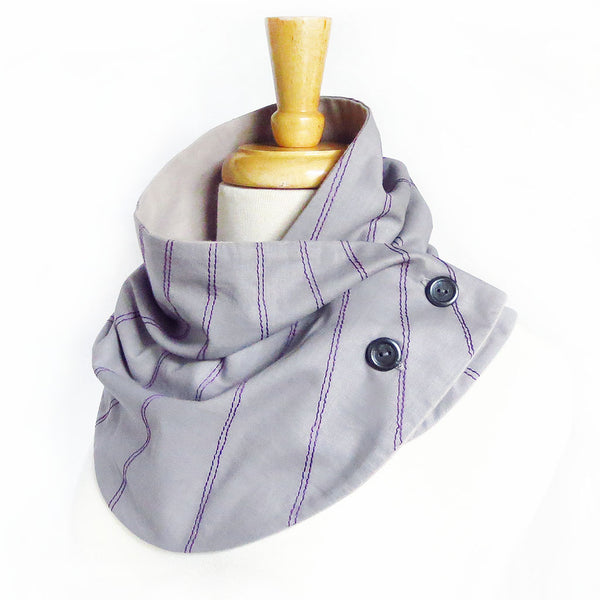 Fabric button scarf with purple stitching on light gray, lined in light gray flannel with two hand painted buttons.