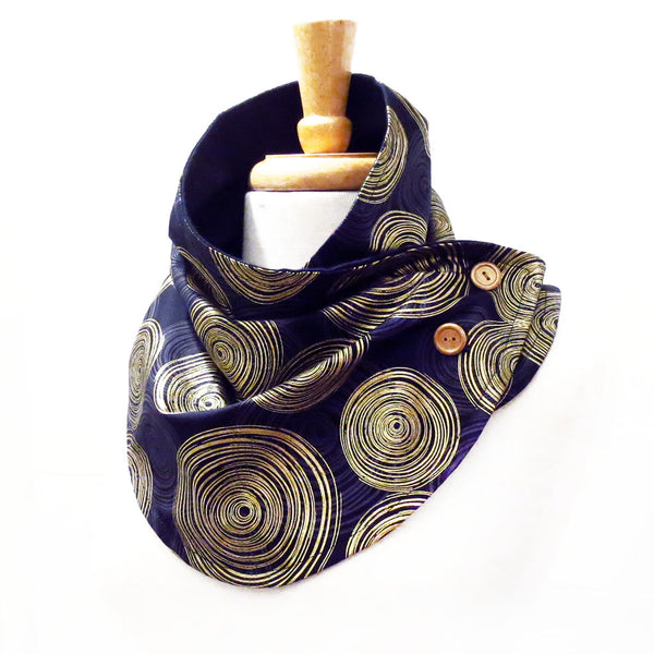 button scarf in a very bold circular geometric print in black, gray, and metallic gold. Buttoned closed with two gold hand painted buttons.