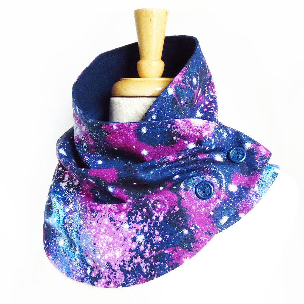 fabric button scarf in purple and blue outer space print, lined in navy blue flannel, with two hand painted dark blue buttons.