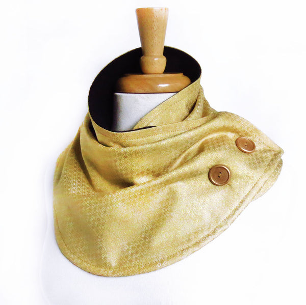 the maya button scarf is in tonal gold print in tiny stars with subtle metallic shine, with gold hand painted buttons, and black flannel lining