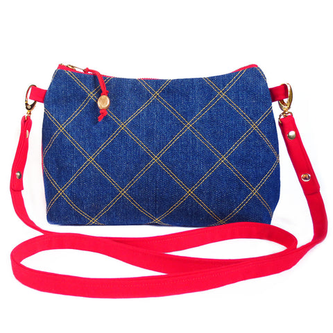 crossbody in dark blue denim quilted with gold thread, with red denim strap and back. 