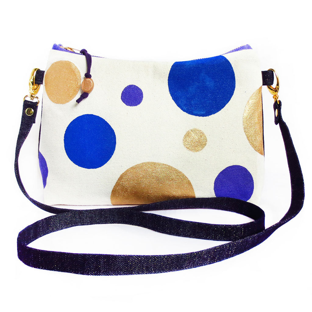 crossbody bag with hand painted polka dots in blue, purple and gold on natural canvas, with dark denim with gold metallic threads