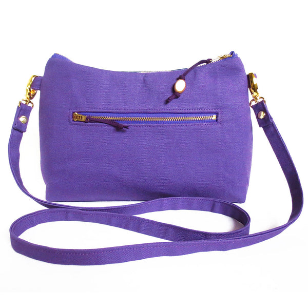 back view of the lola crossbody bag in bright purple canvas, with a 7" zipper pocket
