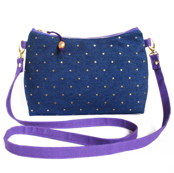 the lola crossbody bag is polka dotted denim and purple canvas
