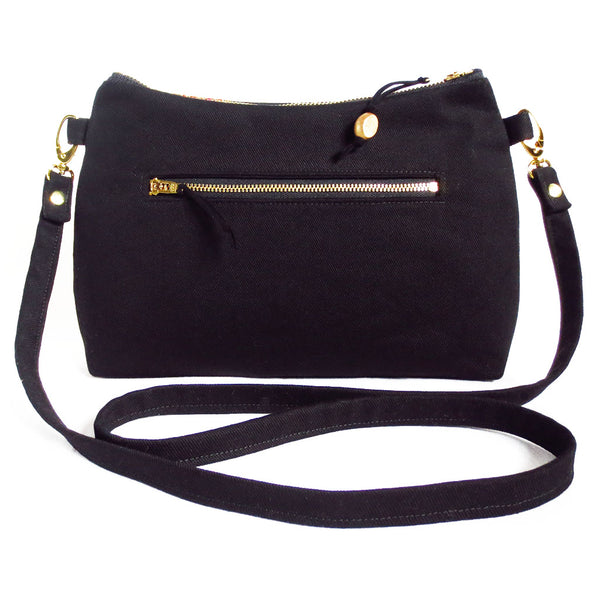 the back of the phoenix crossbody bag is solid black denim with a 7" zippered pocket