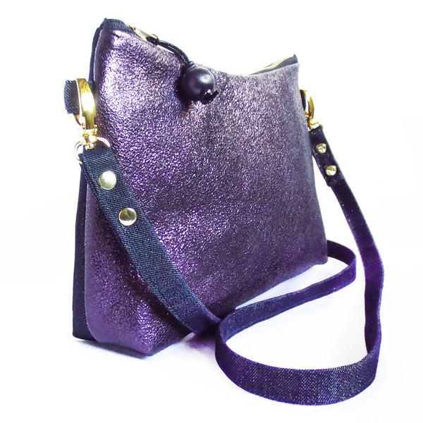 side view of the raina crossbody bag, in purple metallic leather and metallic denim with gold hardware