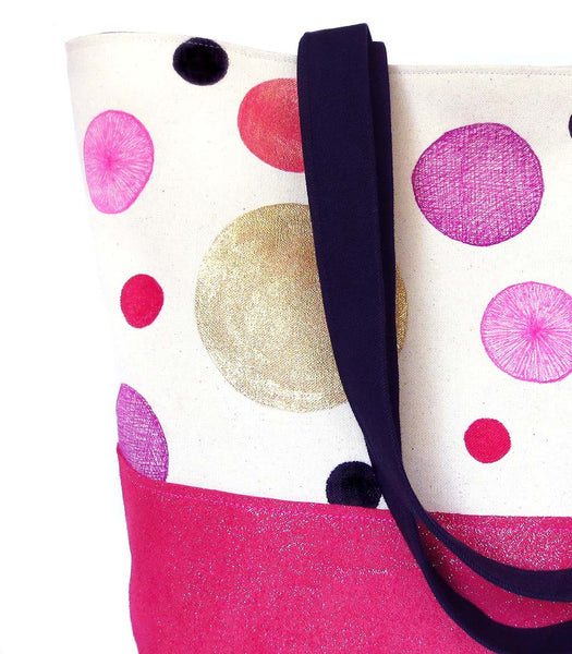 close up of hand painted polka dots on canvas, with black denim and hot pink metallic leather