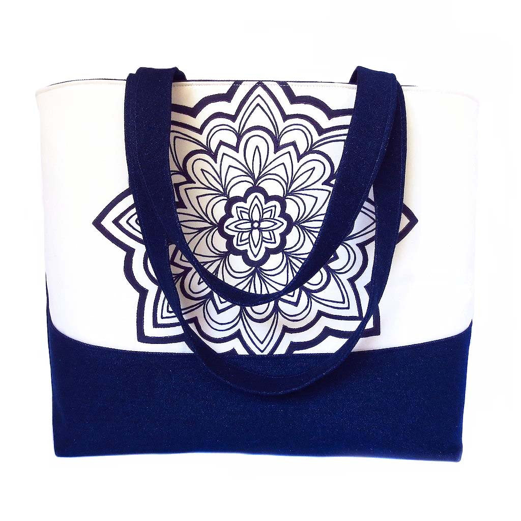 denim tote bag with hand drawn mandala motif in black ink, accented with purple stitching