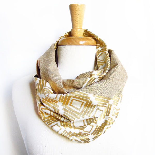the naomi scarf is an infinity scarf made from gold metallic essex linen and a very bold white and gold graphic print, joined together with a diagonal seam