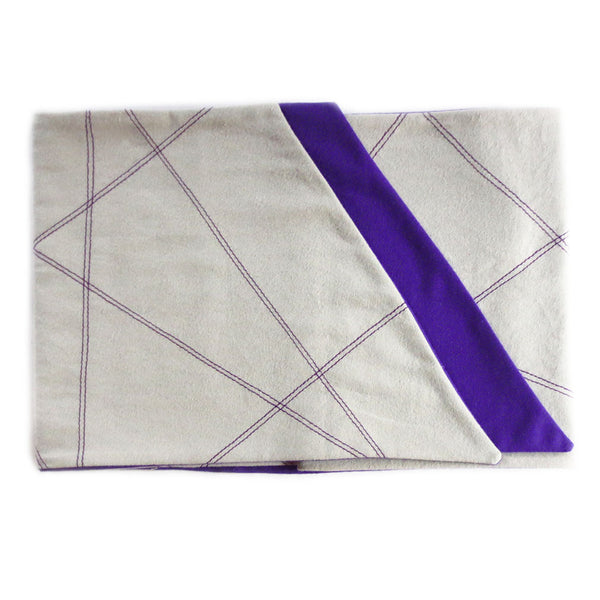 gray flannel scarf for men is folded to show off purple lining, stitched design, and angled edges