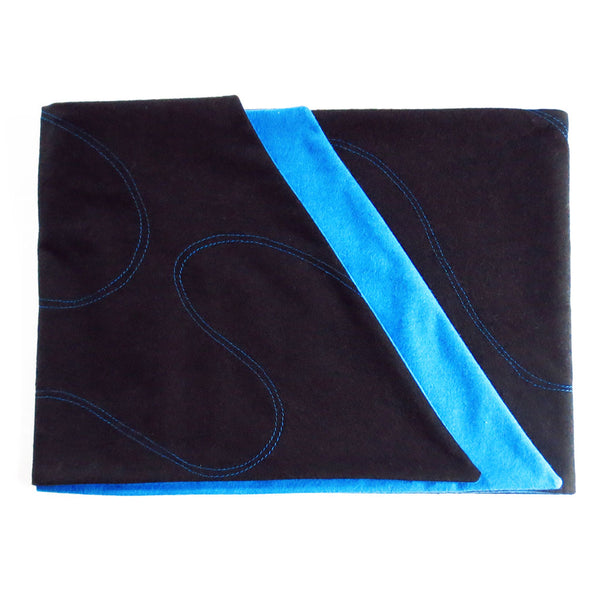 black flannel scarf folded to show off blue lining, angled edges, and blue stitching