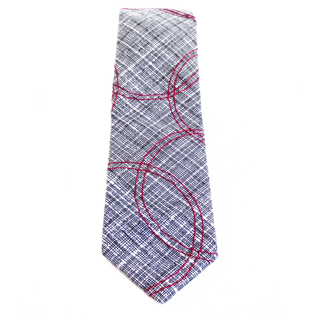 Cotton necktie in black and white, with red circles stitched on top.