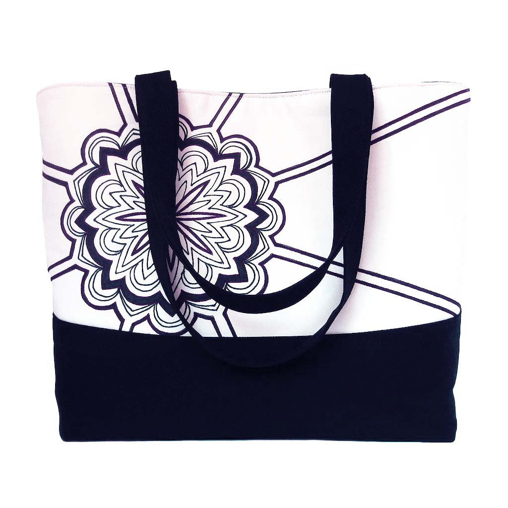 black denim tote bag featuring a mandala-style motif hand drawn in black ink, and accented with red stitching