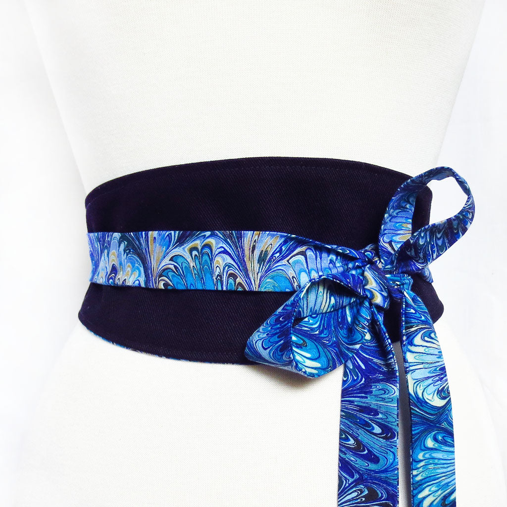 black denim obi style belt with long ties in a blue book marble print cotton, tied in a bow off to one side